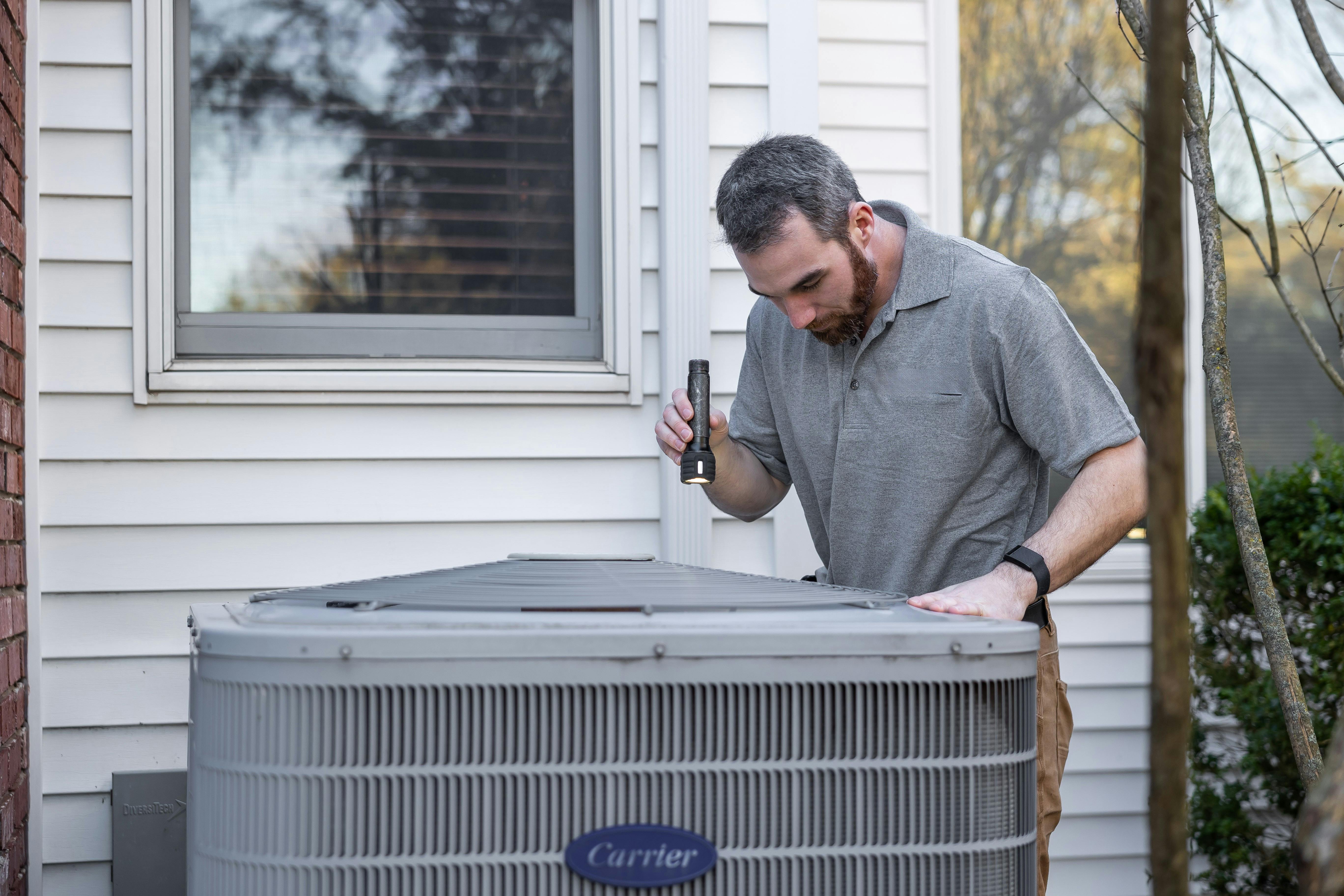 HVAC technician servicing an air conditioning unit — HVAC digital marketing
